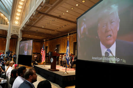 U.S. President Donald Trump is seen on a video screen during a U.S. Citizenship and Immigration Services (USCIS) naturalization ceremony at the New York Public Library in Manhattan, New York, U.S., July 3, 2018. REUTERS/Shannon Stapleton/Files