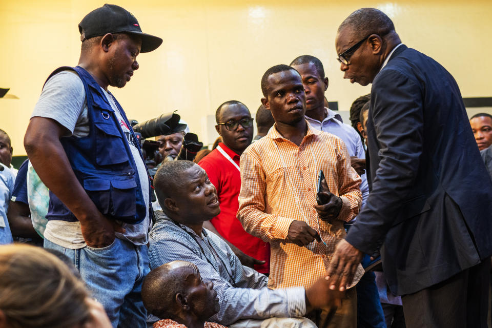 This photo taken on Dec 20 2018 shows AP contributing photographer John Bompengo, center, during a press conference in Kinshasa, Democratic Republic of Congo. Relatives say longtime Associated Press contributor John Bompengo has died of COVID-19 in Congo's capital. Bompengo, who had covered his country's political turmoil over the course of 16 years, died Saturday, June 20, 2020 at a Kinshasa hospital. (AP Photo/Jerome Delay)