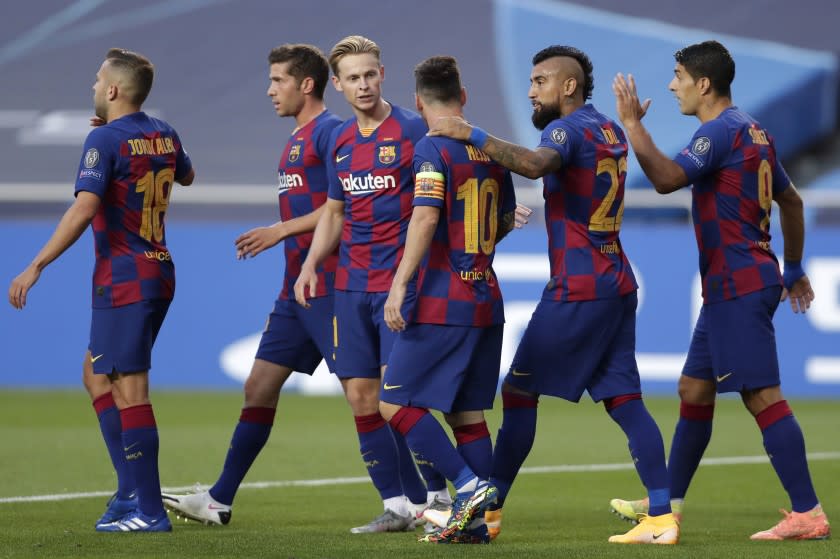 Players of Barcelona celebrate their sides first goal during the Champions League quarterfinal match between FC Barcelona and Bayern Munich at the Luz stadium in Lisbon, Portugal, Friday, Aug. 14, 2020. (AP Photo/Manu Fernandez/Pool)