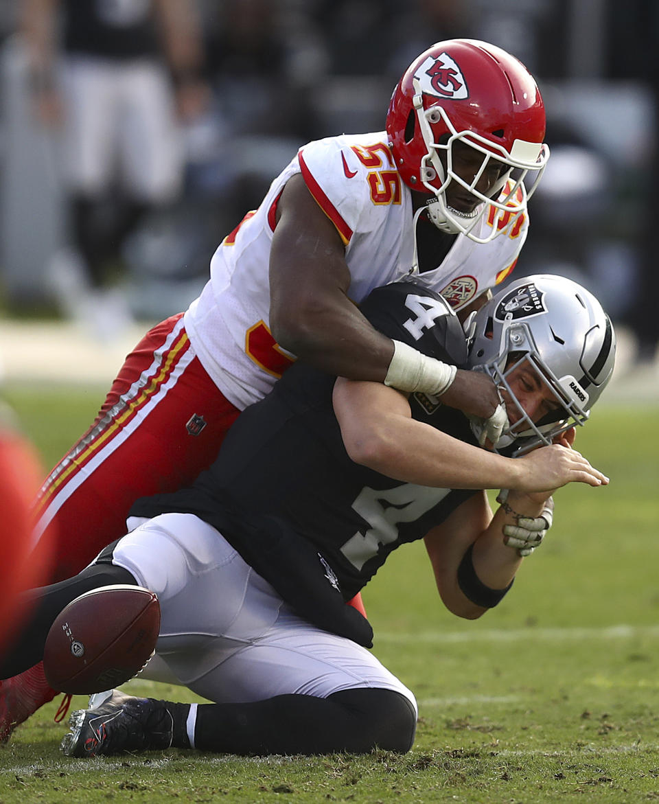 Oakland Raiders quarterback Derek Carr (4) loses the ball as he is hit by Kansas City Chiefs linebacker Dee Ford (55) during the second half of an NFL football game in Oakland, Calif., Sunday, Dec. 2, 2018. The Raiders recovered the ball. (AP Photo/Ben Margot)