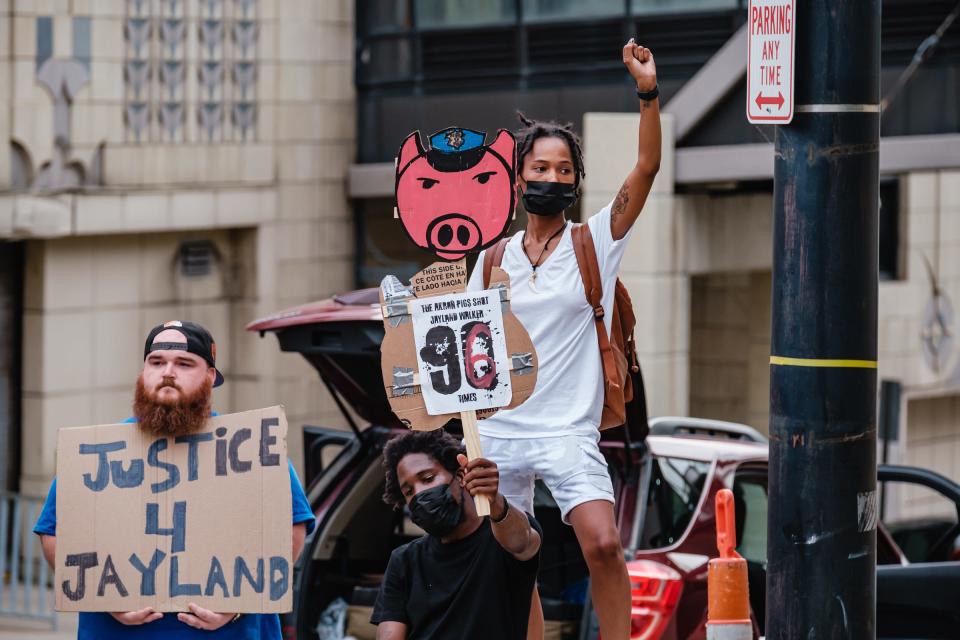 Joshua K. of Akron, from left, a man who didn't give his name, and Winter Carter, 23, of Akron, protest the shooting death of Jayland Walker on Monday.