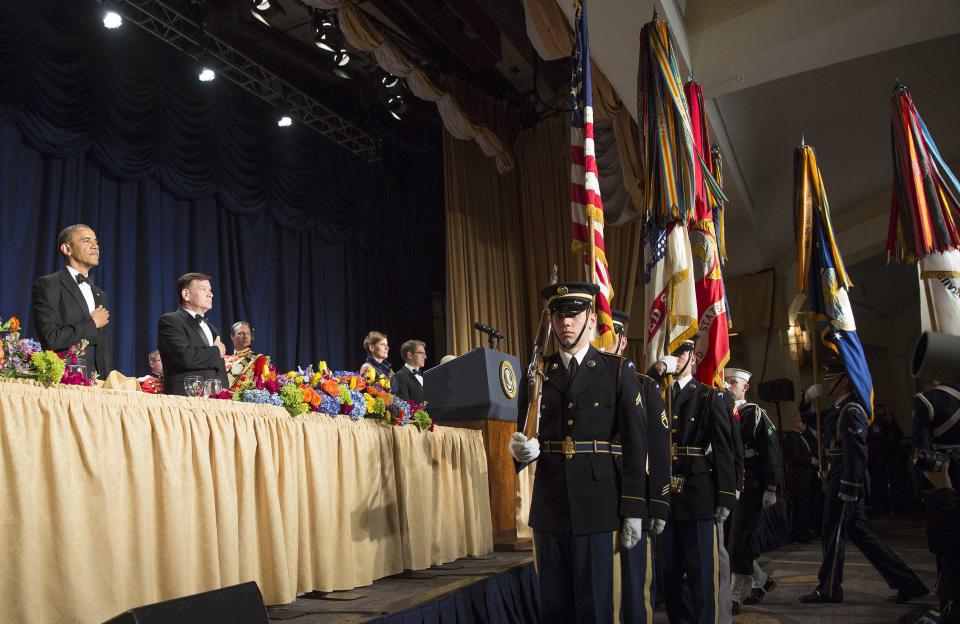 U.S. President Barack Obama (L) stands during the posting of colors at the White House Correspondents' Association Dinner in Washington May 3, 2014. (REUTERS/Joshua Roberts)