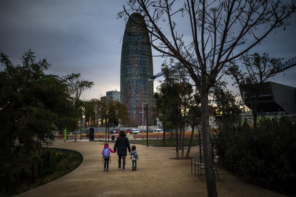 Victoria Martinez, 44, walks with her daughters to the school in Barcelona, Spain, Monday, Feb. 8, 2021. By May this year, barring any surprises, Martinez will complete a change of both gender and identity at a civil registry in Barcelona, finally closing a patience-wearing chapter that has been stretched during the pandemic. The process, in her own words, has also been “humiliating.”(AP Photo/Emilio Morenatti)