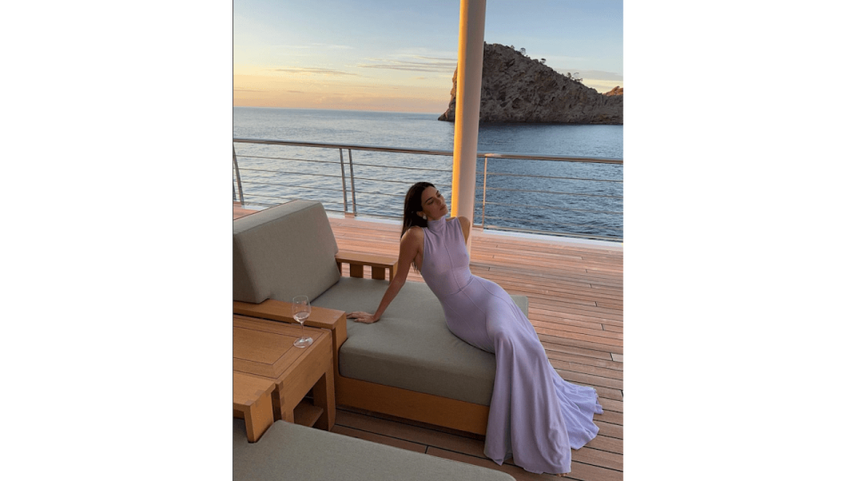 While enjoying a girls' trip in Mallorca, Spain, with her younger sister Kylie, Kendall Jenner is  the yacht wearing a lilac dress by Khaite, while drinking wine