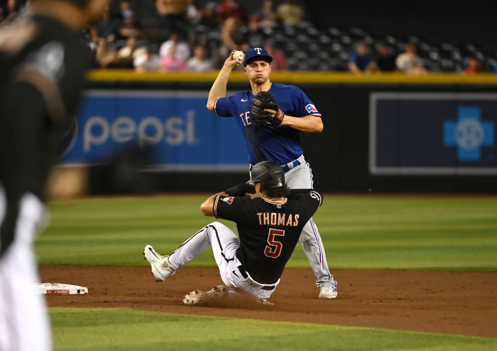  Corey Seager #5 of the Texas Rangers turns a double play on a ground ball hit by Jace Peterson #6 of the Arizona Diamondbacks as Alek Thomas #5 is forced out at second base during the second inning at Chase Field on August 22, 2023. 