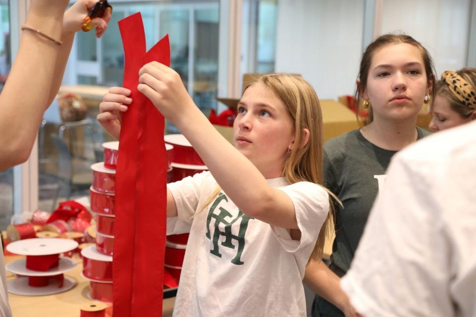 Students at the all-girls private Harpeth Hall make red ribbons for mailboxes to honor the memories of the victims of the 2023 Covenant School shootings. Harpeth Hall received thousands of requests for the ribbons