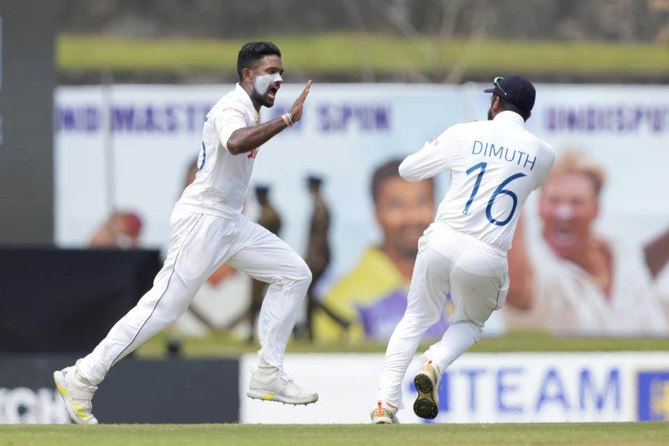 Sri Lanka's Ramesh Mendis, left, celebrates taking the wicket of Australia's Usman Khawaja with teammates during the first day of the second cricket test match between Australia and Sri Lanka in Galle, Sri Lanka, Friday, July 8, 2022. (AP Photo/Eranga Jayawardena)