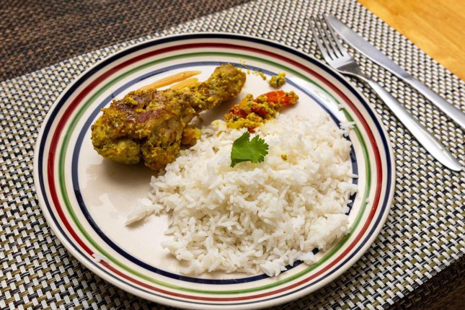 Un plato de pollo al curry con coco preparado por Naylín Sánchez, de 48 años, y Adrienne Rosquete, de 15 (madre e hija) durante una clase de cocina organizada por la Escuela de Hospitalidad de la FIU sobre cómo cocinar comidas saludables en tiempo real, desde su casa en Verde Gardens, una comunidad de 145 viviendas adosadas para ex personas sin hogar, en Homestead, Florida, el martes 24 de octubre de 2023.