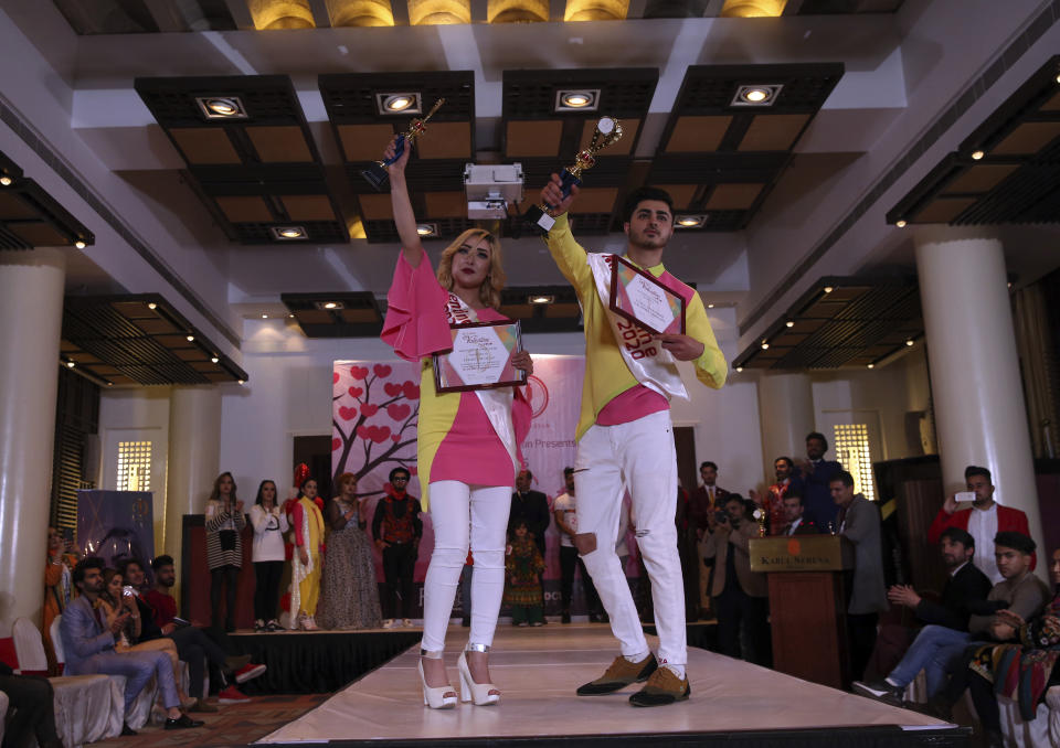 Afghan models Jalil Salimi, right and Salma Hussaini, left, pose with their trophies after winning Mr and Miss Valentine tittle on stage of Mr. and Miss. Valentines 2020 contest, in Valentines Day in Kabul, Afghanistan, Friday, Feb. 14, 2020. (AP Photo/Rahmat Gul)