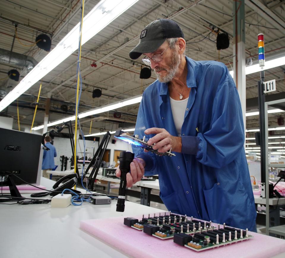 Mark Couto, from Middleboro, a manufacturing engineer with Atrenne in Brockton, inspects new circuit boards made in the company's plant on Wednesday, Sept. 7, 2022.