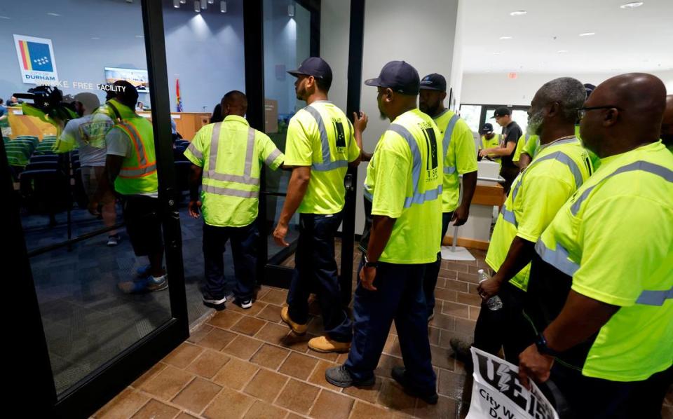 Sanitation workers head into the Durham city council chambers to attend a council work session at City Hall in Durham, N.C., Thursday, Sept. 7, 2023.