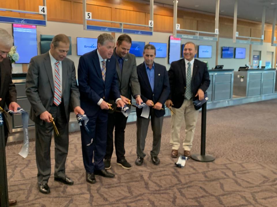 State officials and airline executives cut the ribbon at Breeze Airways' ticket counter to mark the opening of the airline's base at T.F. Green Airport