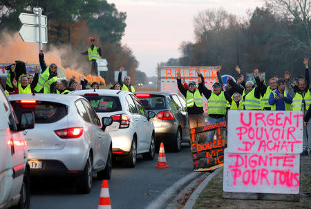 Protesters wearing yellow vests, the symbol of a French drivers' protest against higher diesel fuel prices, occupy a roundabout in Cissac-Medoc, France, December 5, 2018. The slogan reads "Urgent, purchase power, dignity for all". REUTERS/Regis Duvignau