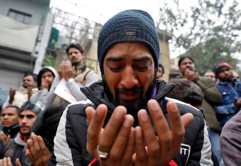 A Muslim man cries as he offers prayers during a protest against a new citizenship law, in Delhi