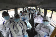 Health workers arrive on a bus to conduct a free medical checkup at residential building in Mumbai, India, Thursday, July 2, 2020. Indian Prime Minister Narendra Modi said in a live address Tuesday that the country's coronavirus death rate is under control, but that the country is at a "critical juncture." But since the lockdown was lifted, the caseload has shot up, making India the world's fourth-worst affected country. (AP Photo/Rafiq Maqbool)