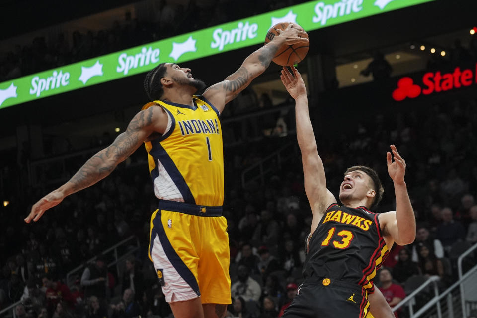 Atlanta Hawks guard Bogdan Bogdanovic (13) has his shot blocked by Indiana Pacers forward Obi Toppin (1) during the first half of an NBA basketball game Friday, Jan. 12, 2024, in Atlanta. (AP Photo/John Bazemore)