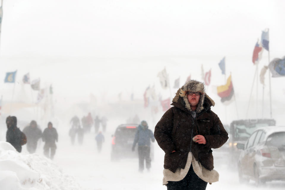 A camper walks through high winds during a blizzard.