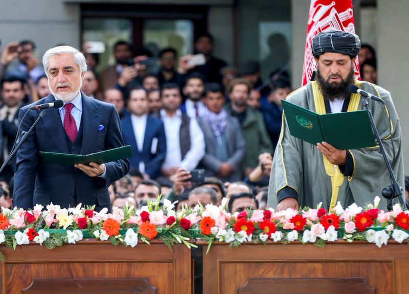 Afghanistan's former Chief Executive Officer Abdullah Abdullah takes an oath during his swearing-in ceremony as Afghanistan's president, accompanied by cleric Shahzada Shahid, in Kabul