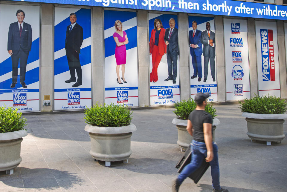 FILE - Images of Fox News personalities, from left, Tucker Carlson, Sean Hannity, Laura Ingraham, Maria Bartiromo, Stuart Varney, Neil Cavuto and Charles Payne appear outside News Corporation headquarters in New York on July 31, 2021. In defending itself against a massive defamation lawsuit over how Fox covered false claims surrounding the 2020 presidential election, the network is relying on a 1964 Supreme Court ruling that makes it difficult to successfully sue media organizations for libel. (AP Photo/Ted Shaffrey, File)