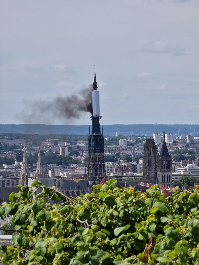 Smoke billows from the spire of Rouen Cathedral in Rouen, northern France on July 11, 2024. Mayor of Rouen Nicolas Mayer-Rossignol said midday on X, that a fire was in progress on the cathedral showing a photograph of a plume of smoke escaping from scaffolding surrounding the spire. (Photo by Patrick STREIFF / AFP)