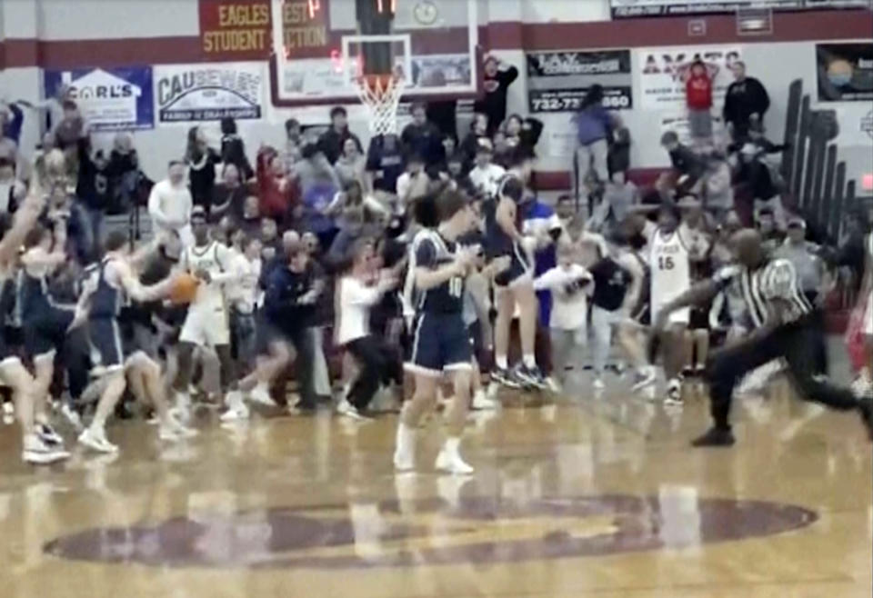 In this image taken from video provided by Joshua Clyburn, a game official, right, signals good basket as Manasquan players celebrate after Griffin Linstra made a basket in the closing second against Camden in the NJSIAA Group Tournament semifinal sound group 2 high school basketball game, Tuesday, March 5, 2024, in Berkley Township, N.J. Manasquan initially was declared the winner, however, the call was soon overturned when the referees discussed the shot and concluded it came after the buzzer, giving Camden a 46-45 win. (Joshua Clyburn via AP)