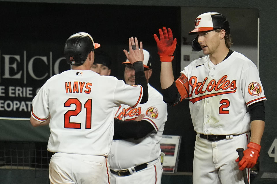 Baltimore Orioles' Austin Hays (21) is greeted near the dugout by Gunnar Henderson (2) and teammates after scoring on a single by Adam Frazier against the Chicago White Sox during the fifth inning of a baseball game, Tuesday, Aug. 29, 2023, in Baltimore. (AP Photo/Julio Cortez)