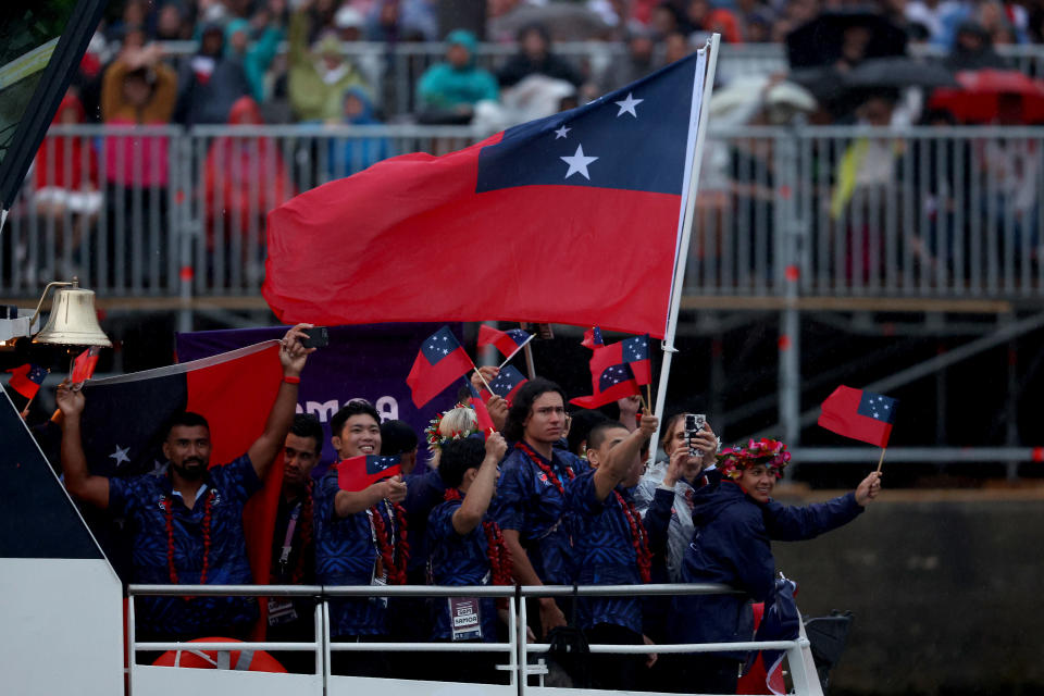 PARIS, FRANCE - JULY 26: Athletes of Team Samoa wave flags on the athletes' parade team boat along the River Seine during the opening ceremony of the Olympic Games Paris 2024 on July 26, 2024 in Paris, France. (Photo by Kevin C. Cox/Getty Images)