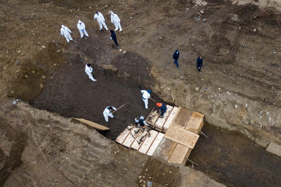 coronavirus covid 19 burial trenches inmates burying unclaimed bodies wooden caskets hart island potters field new york city cemetery nyc bronx april 9 2020 04 09T164235Z_1389564795_RC241G91KIPT_RTRMADP_3_HEALTH CORONAVIRUS USA HART ISLAND.JPG