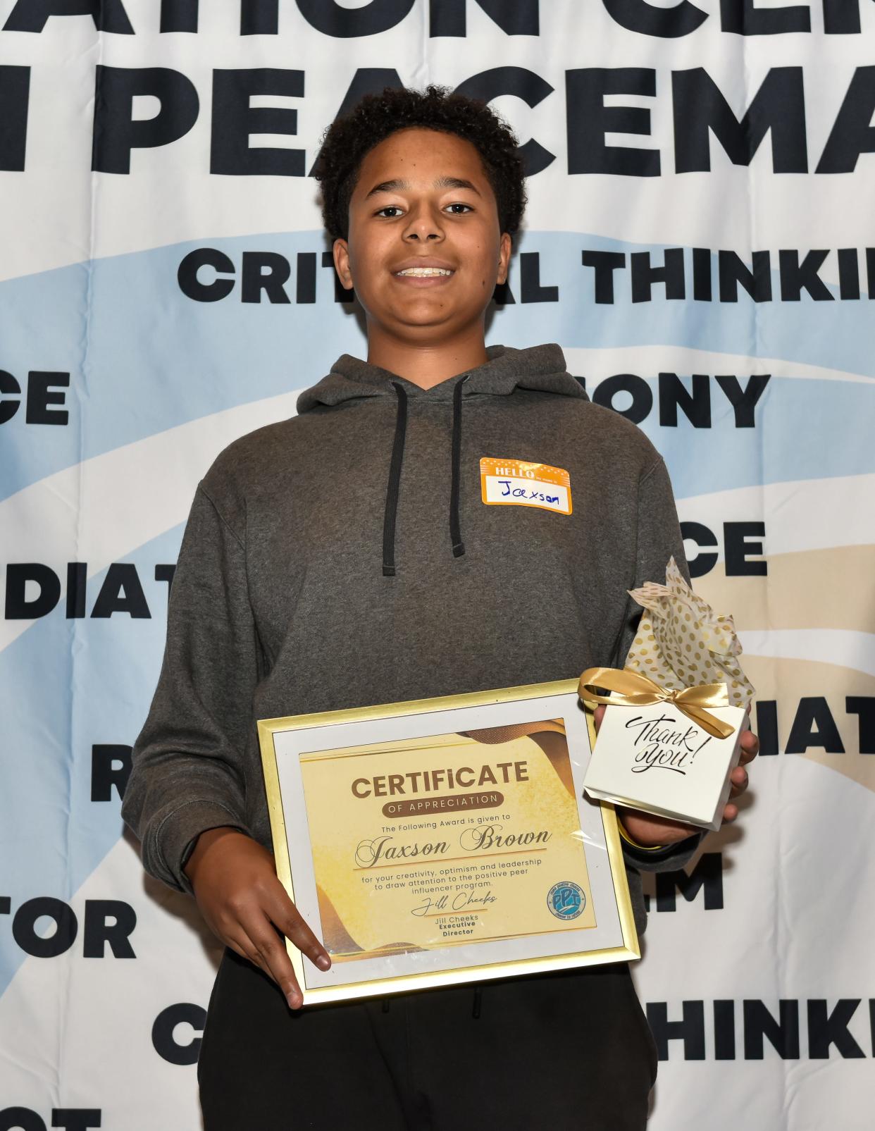 New Hampstead High School student Jaxon Brown shows off his 2024 Positive Peer Influencer Logo Design Winner award and gift during the Mediation Center of the Coastal Empire's annual Youth Awards ceremony on April 17, 2024 at Herschel V. Jenkins High School