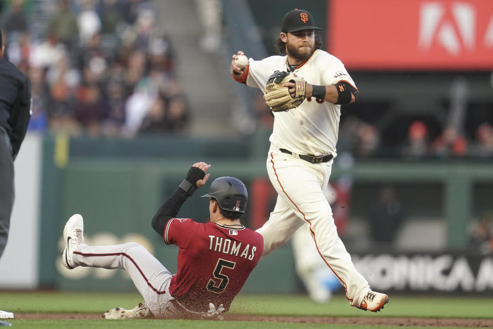 San Francisco Giants shortstop Brandon Crawford, right, throws to first base after forcing Arizona Diamondbacks' Alek Thomas (5) out at second base during the third inning of a baseball game in San Francisco, Monday, July 11, 2022. (AP Photo/Jeff Chiu)