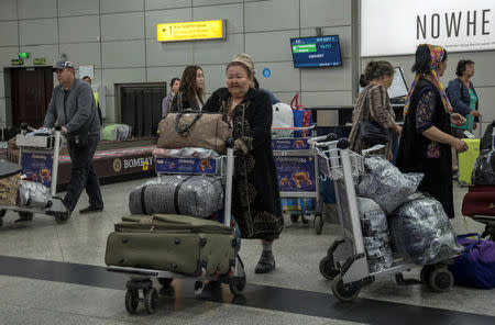 FILE PHOTO: People, including passengers of a flight from the Turkmen capital Ashgabat, gather in the baggage claim area upon their arrival at Almaty International Airport, Kazakhstan April 5, 2019. REUTERS/Mariya Gordeyeva