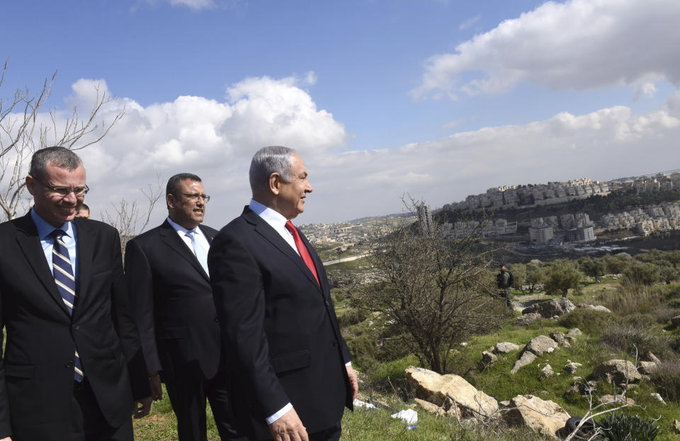 Israeli Prime Minister Benjamin Netanyahu, center, stands with Jerusalem Mayor Moshe Leon, second left, as he visits the area where a new neighborhood is to be built in the Israeli West Bank Israeli settlement of Har Homa, Thursday, Feb. 20, 2020. (Debbie Hill/Pool via AP)