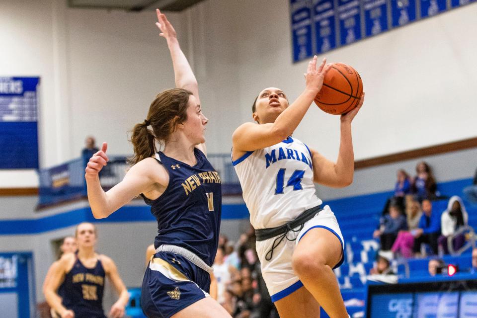 Marian's Nevaeh Foster (14) drives against New Prairie's Jayden Flagg (11) during the Marian vs. New Prairie girls sectional basketball game Friday, Feb. 3, 2023 at Marian High School.