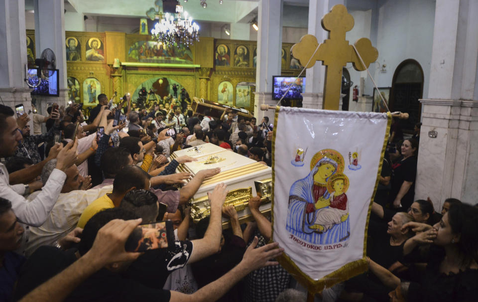 FILE - Mourners attend a service for victims of a fire in a crowded church that killed dozens, at the Blessed Virgin Mary Church in Warraq, greater Cairo, Sunday, Aug. 14, 2022. The fire at the Martyr Abu Sefein Church in Imbaba, one of Egypt’s most densely populated neighborhoods, left many families devastated, striking a Christian community that is one of the world’s oldest, but is also no stranger to sadness. A minority in Egypt, Coptic Orthodox Christians have faced deadly attacks by Islamist extremists, restrictions on church building and outbursts of sectarian-motivated violence in recent decades. (AP Photo/Tarek Wajeh, File)