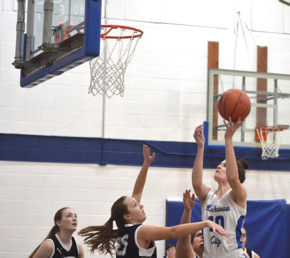 Mackinaw City junior center Madison Smith (10) puts up a left-handed shot over Ellsworth defenders during a varsity girls basketball contest in Mackinaw City on Thursday.