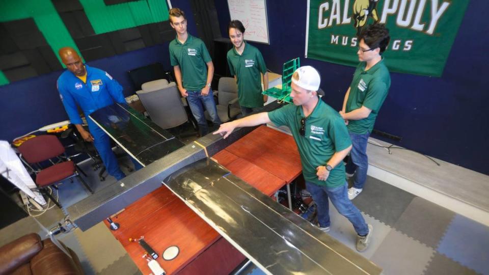 Cal Poly graduate and NASA astronaut Victor Glover talks to engineering students from left Cole Bushur, Nicholas Toal and Andrew Whitacre. Andrew Sugamele points out details on the electric powered, autonomous flight aircraft they built..