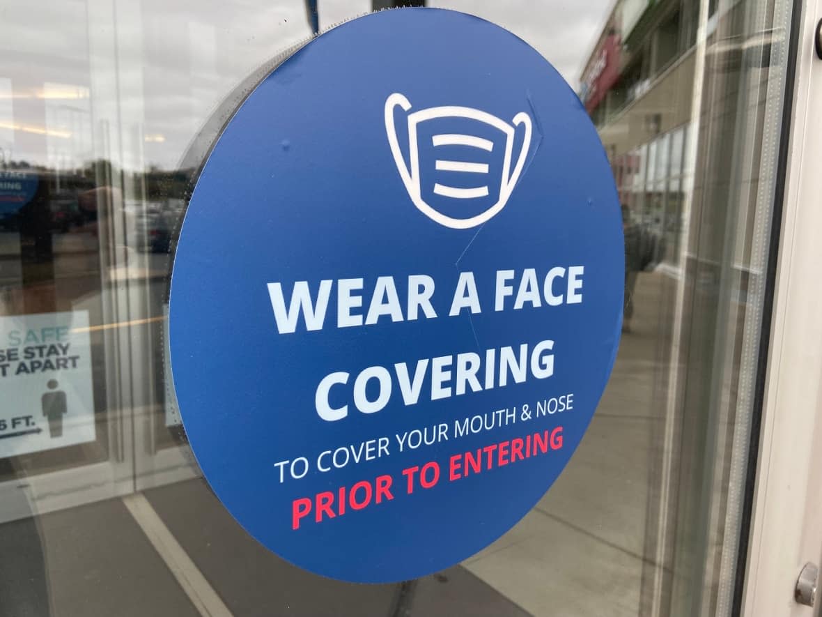 A sign instructs people to wear a face covering before entering a building. Nova Scotia reported 503 new COVID-19 cases on Sunday. (CBC - image credit)