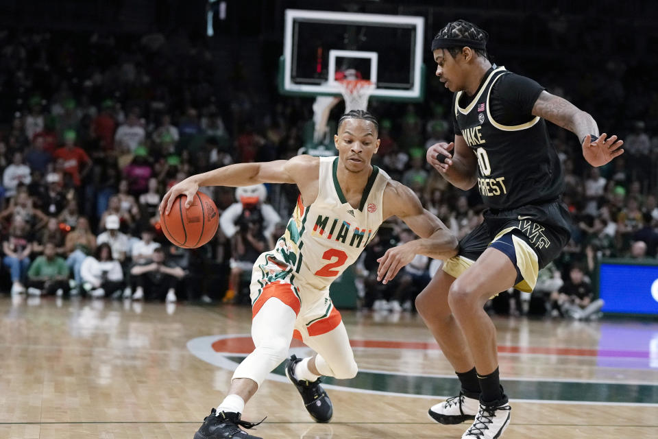 Miami guard Isaiah Wong (2) controls the ball under pressure from Wake Forest guard Damari Monsanto (30) during the first half of an NCAA college basketball game, Saturday, Feb. 18, 2023, Coral Gables, Fla. (AP Photo/Rebecca Blackwell)