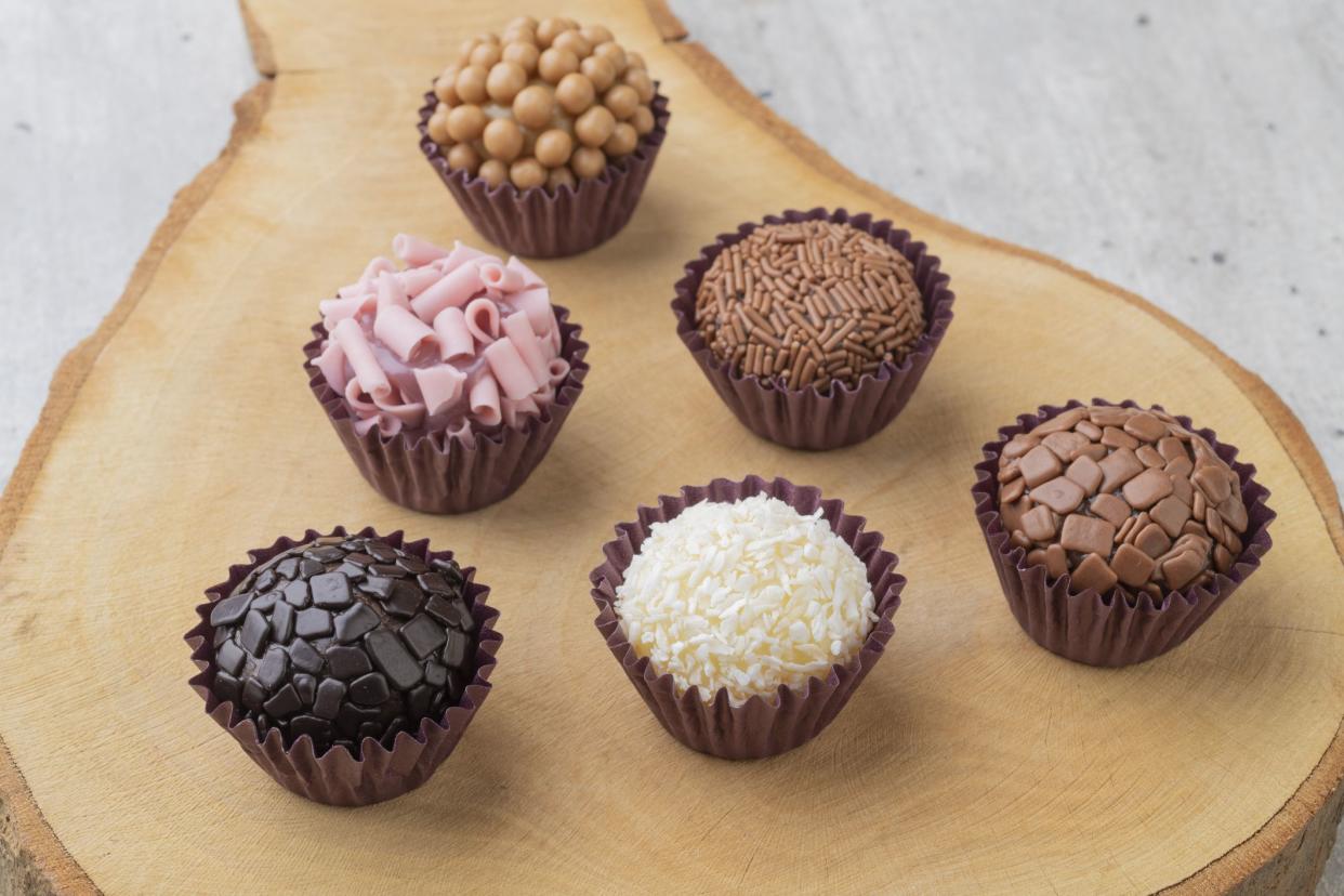 Typical brazilian brigadeiros, various flavors over wooden board.