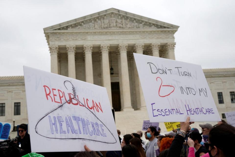 Los manifestantes sostienen carteles durante una protesta afuera de la Corte Suprema de los EE.UU. por los documentos filtrados que sugieren el derrocamiento de Roe vs Wade (Reuters)