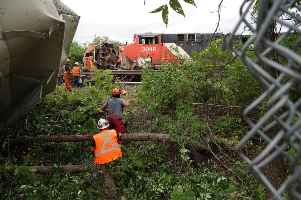 Workers check out one of the trains in a collision in Prescott, Ont., around 10:30 a.m. Sept. 2, 2021.