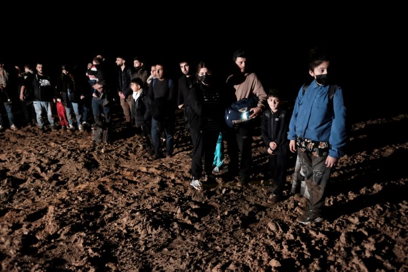 Migrants cross a field next to the Belarus-Latvia border near Vorzova