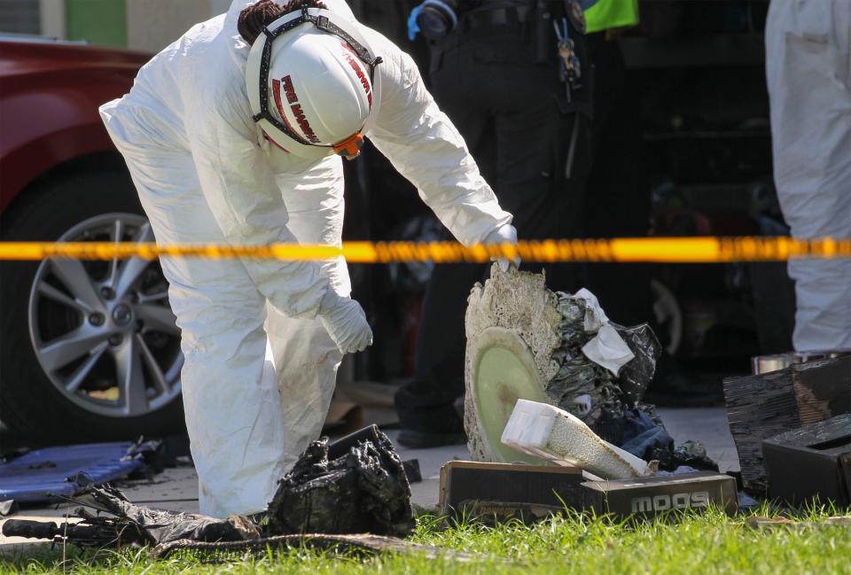 A St. Lucie County Fire District investigator looks through the remains of a structure fire in the 2600 block of Southwest Cactus Circle on Monday, May 1, 2023, in Port St. Lucie. A 56-year-old man was found dead in the garage, police said. Fire District crews are investigating the cause of the blaze.