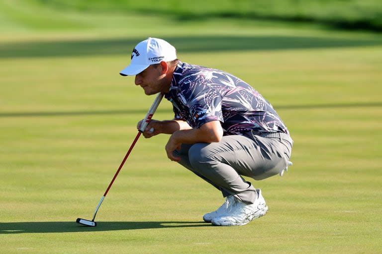 Emiliano Grillo estudia el putt en el green del 14