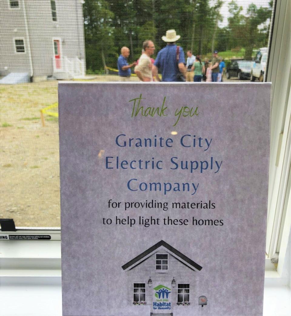 A sign in the window of one of the completed Habitat for Humanity houses in Hingham thanks  one of the contractors who donated materials for the Whiting Street project.