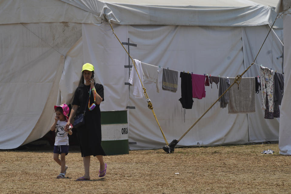 A Ukrainian refugee walks with her child at a camp in Utopia Park in Iztapalapa, Mexico City, Monday, May 2, 2022. (AP Photo/Marco Ugarte)