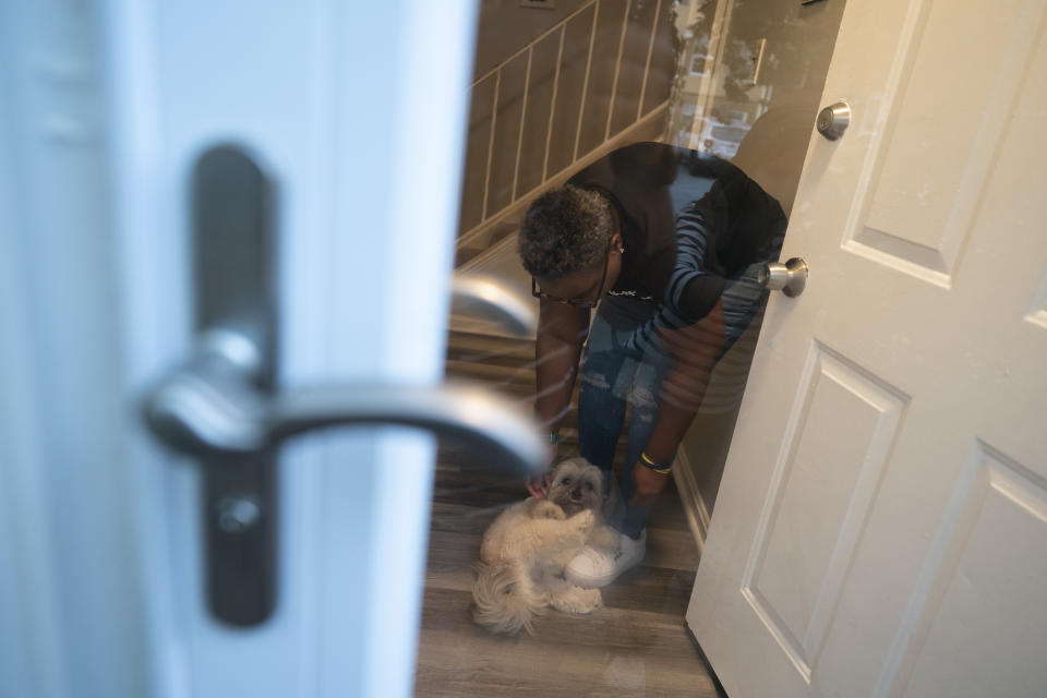 Melanese Marr-Thomas plays with her dog, Ryder, at the entrance of her home in District Heights, Md., on Wednesday, Sept. 21, 2022. (AP Photo/Wong Maye-E)