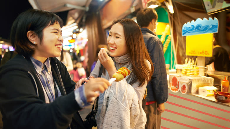 Two foodies eating corndogs