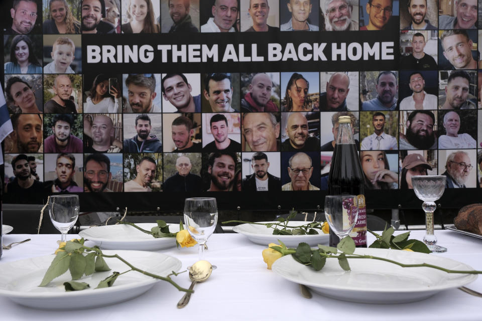 FILE - Pictures of hostages kidnapped during the Oct. 7 Hamas cross-border attack in Israel are placed by a table set during a protest outside the International Court of Justice in The Hague, Netherlands, Friday, Jan. 12, 2024. Israeli Defense Minister Yoav Gallant said Israel was “fighting human animals,” in announcing a complete siege on Gaza two days after Hamas’ attack. (AP Photo/Patrick Post, File)