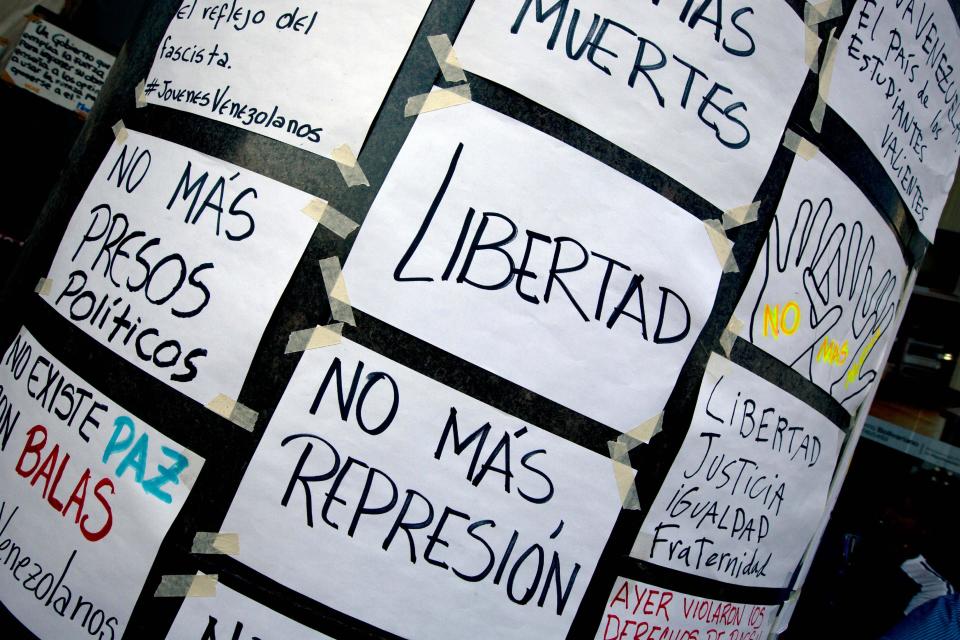 Carteles confeccionados a mano, sujetos a la pared exterior de la oficina de la ONU en Caracas, Venezuela, 25 de marzo de 2014. (AP Foto/Fernando Llano)